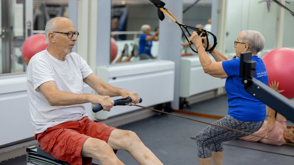 Seniorer tränar tillsammans i ett gym.